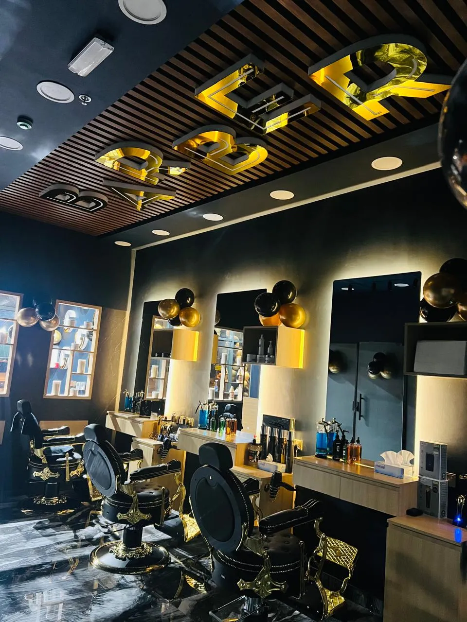 The barber stations and mirrors under the lit BARBER lettering